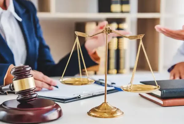 scales-of-justice-gavel-on-desk-lawyers-discussing-2026-01-07-01-44-54-utc 1